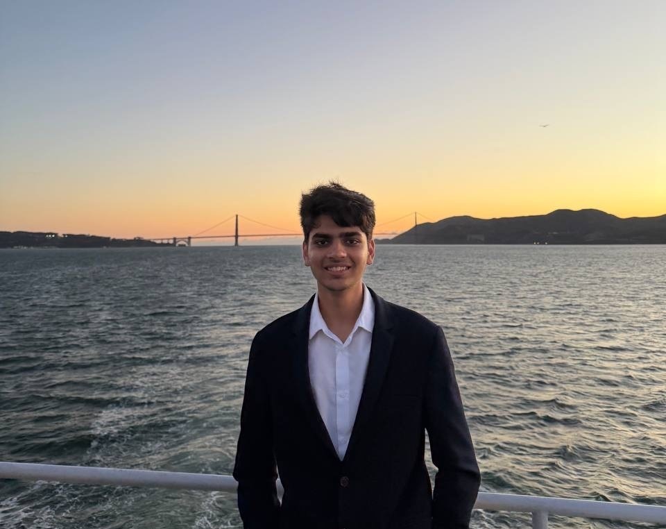 Anushk standing by the water at sunset with the Golden Gate Bridge in the background